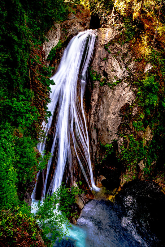 Twin Falls cascading down a moss-lined rock face into a turquoise pool, long exposure